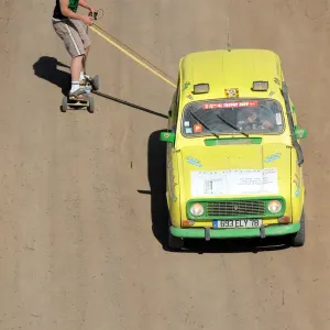 A man on a skate board is pulled by a 4L before the stage from Boudnib to Merzouga A man on a skate board is pulled by a 4L before the stage from Boudnib to Merzouga
