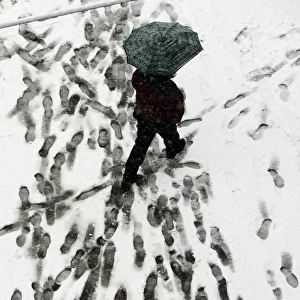 A man walks with his umbrella under snow in downtown Belgrade, 06 March 2006