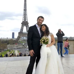Un couple américain et roumain récemment marié pose devant la tour Eiffel le 21 mars.