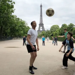 People play football on May 29, 2014 in front of the Eiffel tower, in Paris