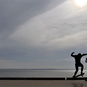 People ride a skateboard along the beach on October 7, 2016 in Saint-Nazaire, western France