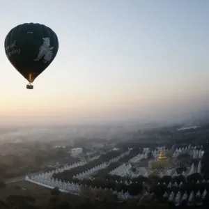 This photo taken on February 5, 2014 shows a hot air balloon flying over a temple This photo taken on February 5, 2014 shows a hot air balloon flying over a temple