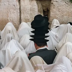 Print of a man carrying multiple hats at the Wailing Wall Print of a man carrying multiple hats at the Wailing Wall