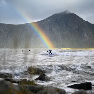 Print of a teenager surfing under a rainbow in northern Norway Print of a teenager surfing under a rainbow in northern Norway