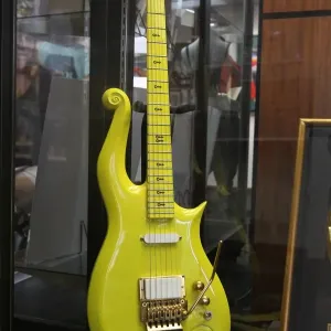 A custom made signature yellow cloud guitar displayed in a print A custom made signature yellow cloud guitar displayed in a print