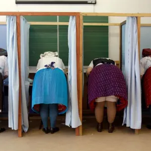 Women dressed in traditional Hungarian outfit prepare their votes in a polling station