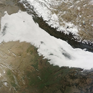 A thick bank of low clouds covers the foothills of the Himalayan mountains with some