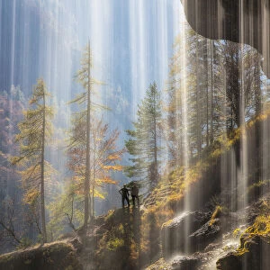 View of hikers from behind the Pericnik Waterfall, Slovenia, October 2018
