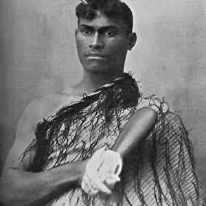A Maori youth carrying the flat greenstone (nephrite) club known as a mere, 1902. Artist: Iles