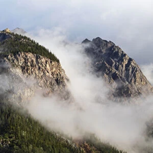 Clouds gather around mountain peaks