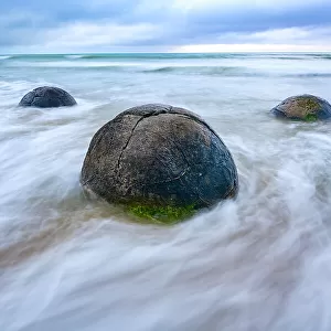 The Moeraki Boulders are large and spherical boulders lying along a stretch of Koekohe Beach