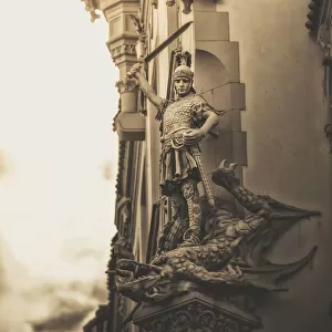 Statue On The Side Of A Building Of A Warrior Slaying A Dragon; Prague, Czech Republic