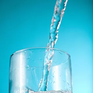 Stream Of Water Being Poured Into A Clear Glass