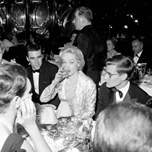 Marlene Dietrich with Yves St. Laurant in Paris sitting at dinner table in