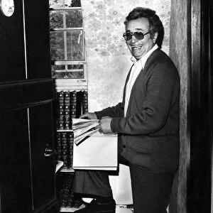 Michael Bentine, in the toilet at his home, browsing through a volume of Encyclopedia