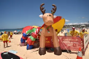 <b class=qtipBold><figcaption>Australia-Christmas-Beach</figcaption></b><br>Surf lifesavers (L) walk past a Christmas tree and an inflatable reindeer on Bondi Beach on Christmas Day in Sydney on December 25, 2016. / AFP PHOTO / PETER PARKS<br><em>© Copyright Agence France-Presse (AFP) - All Rights Reserved</em> Australia-Christmas-Beach