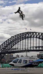 <b class=qtipBold><figcaption>Australia-Us-Motorbike-Helicopter</figcaption></b><br>Travis Pastrana (top) of the US performs a Nac Nac jump on his dirt bike over a hovering 43-foot (13-metre) helicopter (below) in front of the Sydney Harbour Bridge on October 28, 2009. Pastrana has performed other stunts around the world, including jumping out of a plane with no parachute and jumping off his motorbike into the Grand Canyon. AFP PHOTO / Greg WOOD / AFP PHOTO / GREG WOOD<br><em>© Copyright Agence France-Presse (AFP) - All Rights Reserved</em> Australia-Us-Motorbike-Helicopter