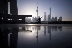<b class=qtipBold><figcaption>China-Society</figcaption></b><br>A man practice Tai Chi with a sword during sunrise at the promenade on the Bund along the Huangpu River, seen against the skyline of the Lujiazui Financial District in Pudong, Shanghai March 17, 2017. / AFP PHOTO / Johannes EISELE<br><em>© Copyright Agence France-Presse (AFP) - All Rights Reserved</em> China-Society