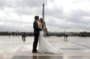 Eiffel Tower Prints: A Chinese maried couple kisses each other in front of the Eiffel tower on February 25