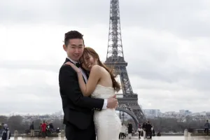 A Chinese maried couple pose in front of the Eiffel tower on February 25, 2014, in Paris