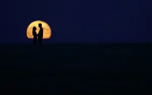 A couple stand in front of the full moon in Burgos on September 9, 2014 A couple stand in front of the full moon in Burgos on September 9, 2014