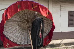 <b class=qtipBold><figcaption>Ghana-Royal-Ceremony-Umbrella</figcaption></b><br>A man carrying a tradionnal umbrella waits during a ceremony following the death of Nana Afia Kobi Serwaa Ampem II, the 13th queen mother of the Asante Kingdom (Asantehemaa), on November 24, 2016 in Kumasi. / AFP PHOTO / CRISTINA ALDEHUELA<br><em>© Copyright Agence France-Presse (AFP) - All Rights Reserved</em> Ghana-Royal-Ceremony-Umbrella