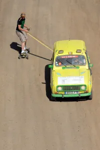 A man on a skate board is pulled by a 4L before the stage from Boudnib to Merzouga A man on a skate board is pulled by a 4L before the stage from Boudnib to Merzouga