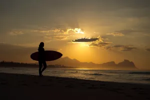 <b class=qtipBold><figcaption>OLY-2016-RIO-FEATURE</figcaption></b><br>A surfer gets in the Atlantic Ocean at sunrise at the Praia da Macumba beach on August 5, 2016 in Rio de Janeiro ahead of the Rio 2016 Olympic Games. Surfing is one of five new sports announced for the Games in Japan, with skateboarding, climbing, karate, and baseball-softball.. / AFP PHOTO / FABRICE COFFRINI<br><em>© Copyright Agence France-Presse (AFP) - All Rights Reserved</em> OLY-2016-RIO-FEATURE