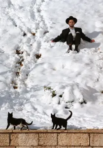 <b class=qtipBold><figcaption>Retro-Israel-Weather</figcaption></b><br>(FILES) An ultra-orthodox Jew plays in the snow 12 January under the gaze of two black cats, near Jerusalem's Western Wall. A thick layer of snow brought Jerusalem to a virtual standstill with buses cancelled and schools closed. / AFP PHOTO / MENAHEM KAHANA<br><em>© © Copyright Agence France-Presse (AFP) - All Rights Reserved</em> Retro-Israel-Weather