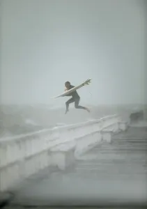 Surfer Jumping Off Port Phillip Bay Pier Australia