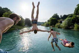 <b class=qtipBold><figcaption>Switzerland-Weather-Travel-Summer</figcaption></b><br>Young men jump into the river Aare on June 21, 2017 in Bern. / AFP PHOTO / Fabrice COFFRINI<br><em>© Copyright Agence France-Presse (AFP) - All Rights Reserved</em> Switzerland-Weather-Travel-Summer