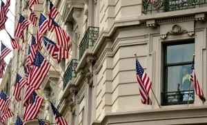 Prints of A man looks trough his room window as Willard Hotel facade is decorated with US flags marking Independence Day in Washington, DC on July 4. / AFP PHOTO / MLADEN ANTONOV USA Prints: Us-Independence-Day-July4
