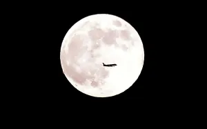 <b class=qtipBold><figcaption>US-MOON-FEATURE</figcaption></b><br>An airplane flies past June's full moon known as the Strawberry Moon on June 27, 2018 in Montebello, California. The Strawberry Moon gets its name from Native Americans on the continent's East Coast for it signalled the time when strawberries were ripe and ready to be picked. / AFP PHOTO / Frederic J. BROWN<br><em>© Copyright Agence France-Presse (AFP) - All Rights Reserved</em> US-MOON-FEATURE