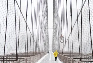 Prints of People cross the Brooklyn Bridge in New York on March 14, 2017 ahead of winter storm Stella / AFP PHOTO / ANGELA WEISS USA Prints: Usa-Weather-Snow-New York