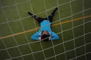 A young player of the Ronda Union Deportiva football club rests on the field during