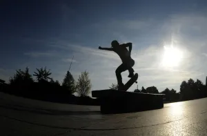 Acrobatics Prints: A youth performs a trick on his skateboard during a warm autumn sunny day on October 4